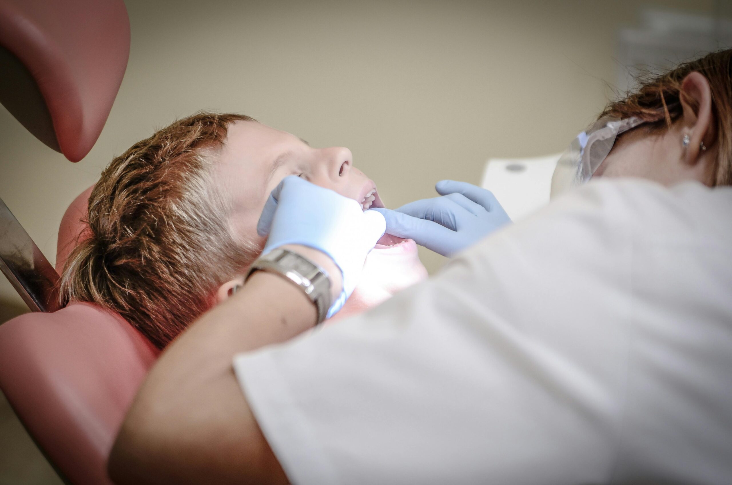 dentist-pain-borowac-cure-52527-52527 A young boy receiving a dental examination by a professional dentist in a clinic setting.